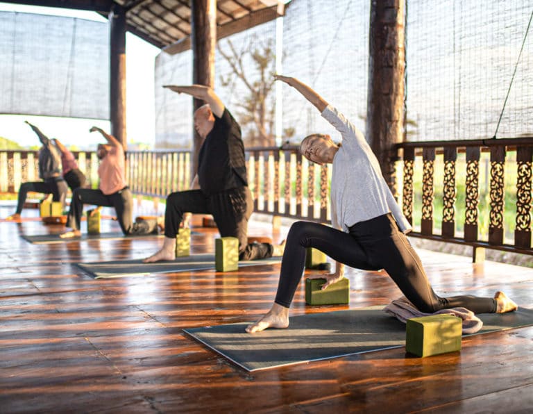 Studends in Lunge at Summer Spring Yoga and Meditation Retreat in Chiang Mai